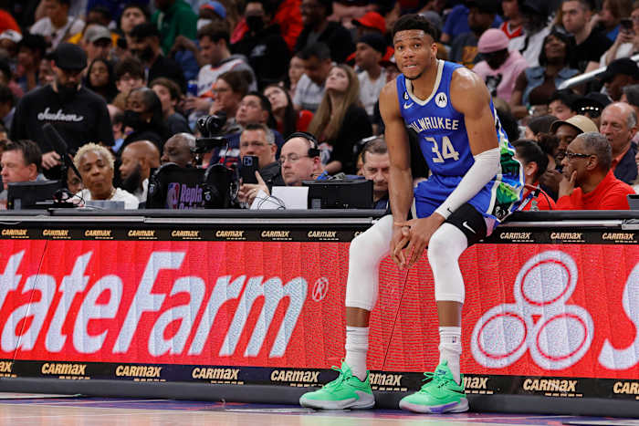 Milwaukee Bucks forward Giannis Antetokounmpo sits on the scorers table during a timeout.